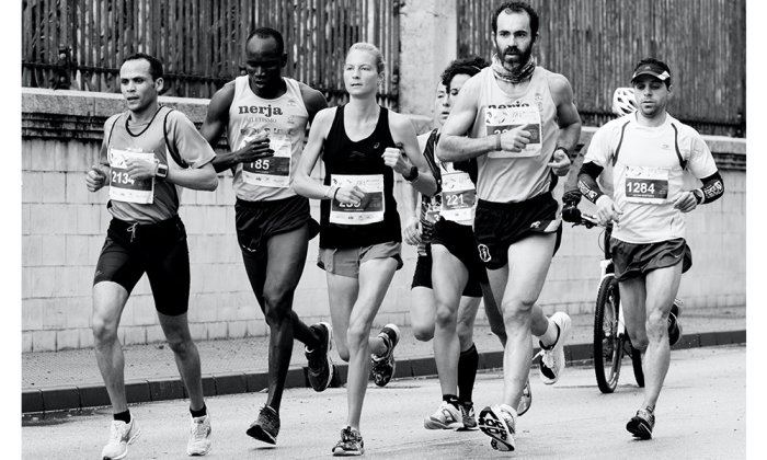 Two strong athletic women sprinter, running on black background